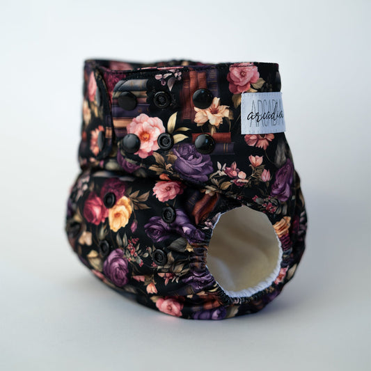 book and floral patterned reusablediaper on a white background