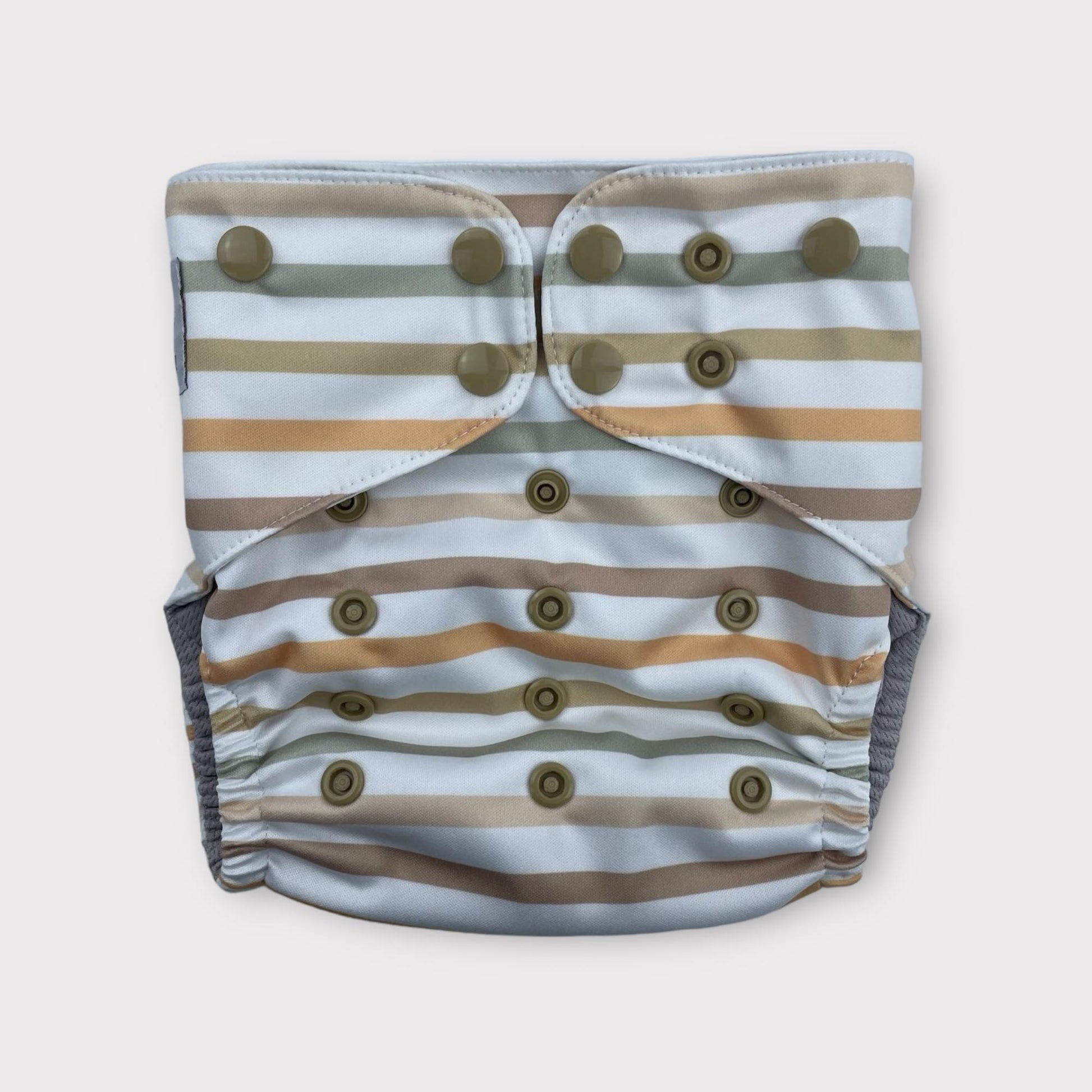 A striped Pocket style cloth diaper, the base color is a bluish-white, with stripes of subdued neutral orange, browns, and green.