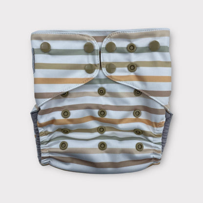 A striped Pocket style cloth diaper, the base color is a bluish-white, with stripes of subdued neutral orange, browns, and green.