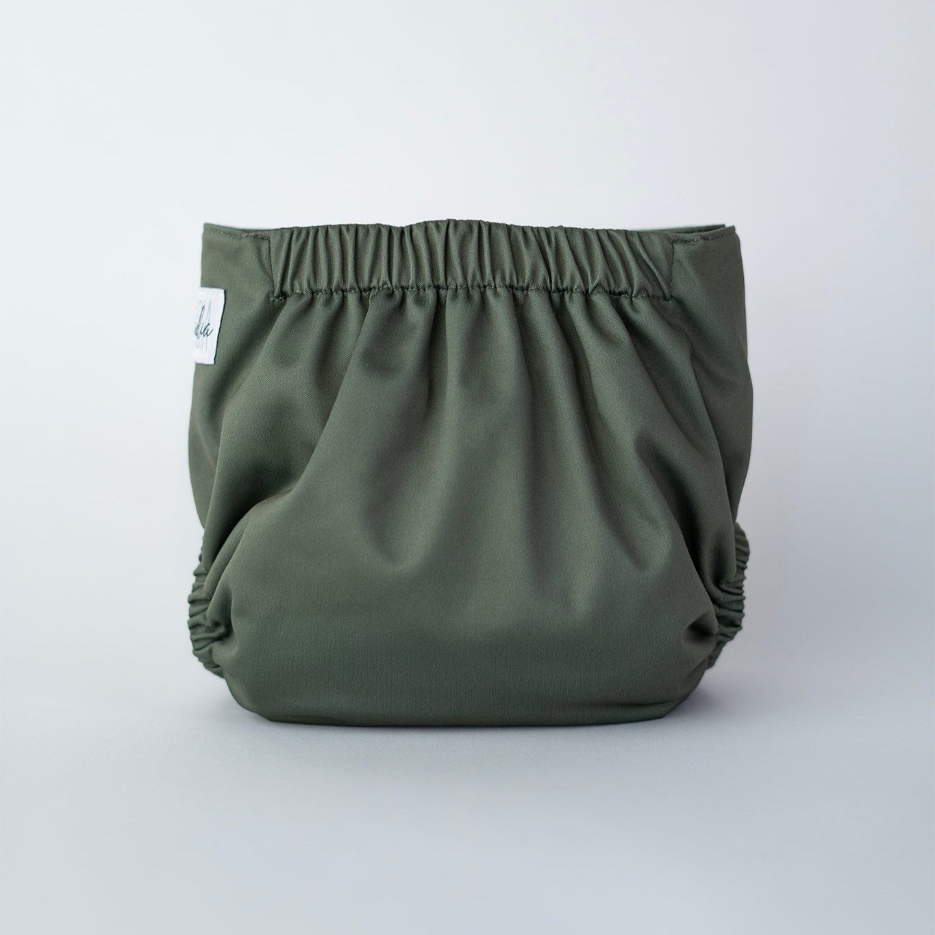 A reusable pocket cloth diaper in a muted, earthy moss green shade named Petrichor. This premium cloth diaper features multiple adjustable snaps for a customizable fit, ensuring comfort and leak protection for babies of all sizes. The soft, elastic leg openings and water resistant outer layer provide both flexibility and reliability. Back view.