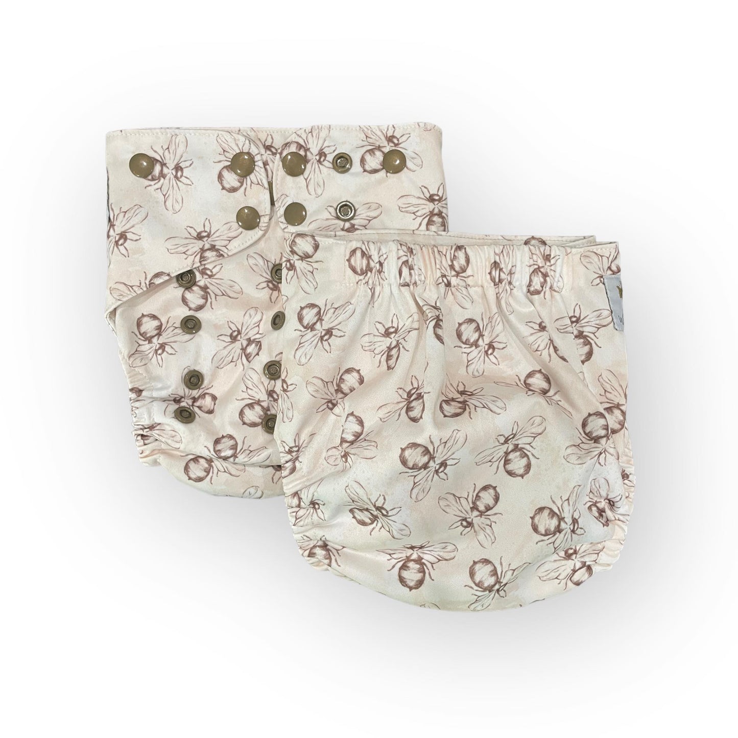  a photo of two pocket cloth diapers with a white background and illustrations of brown bumble bees. One diaper shows the front, the other shows the backj
