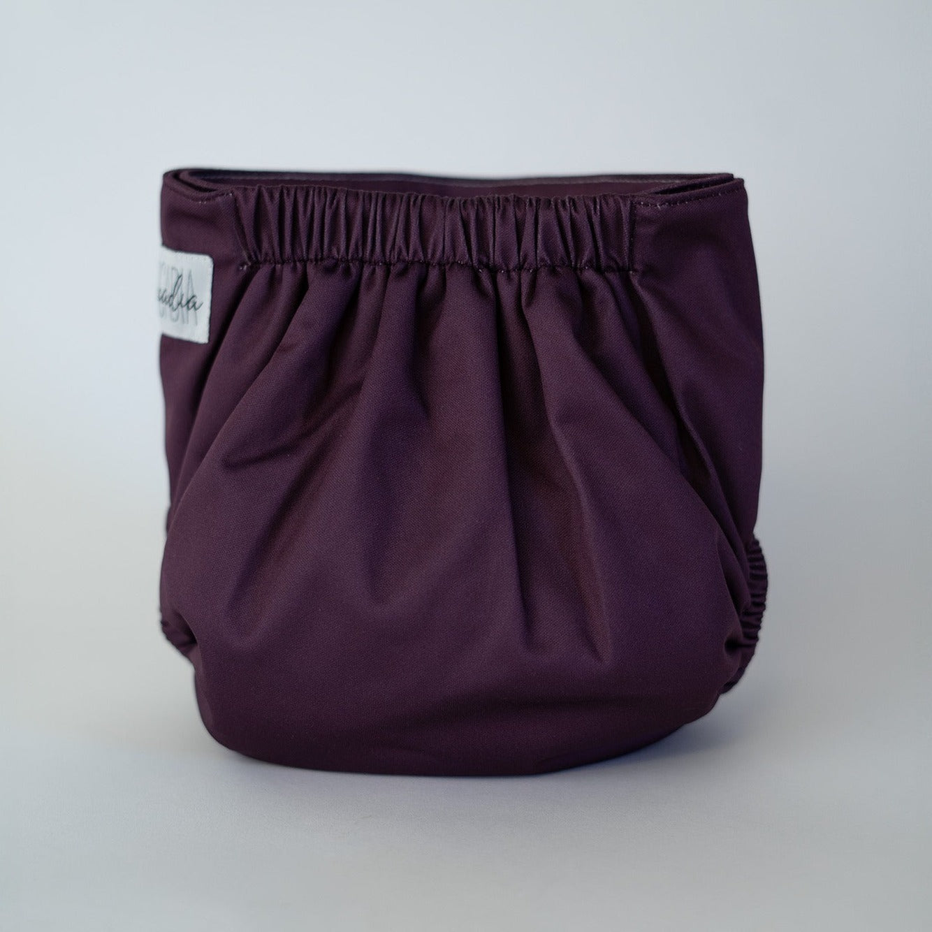 A cloth diaper in a wine burgundy color, rear view.