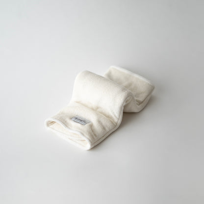 A white trifold style bamboo terry insert for cloth diapers, displayed folded on a light background in an inchworm formation.