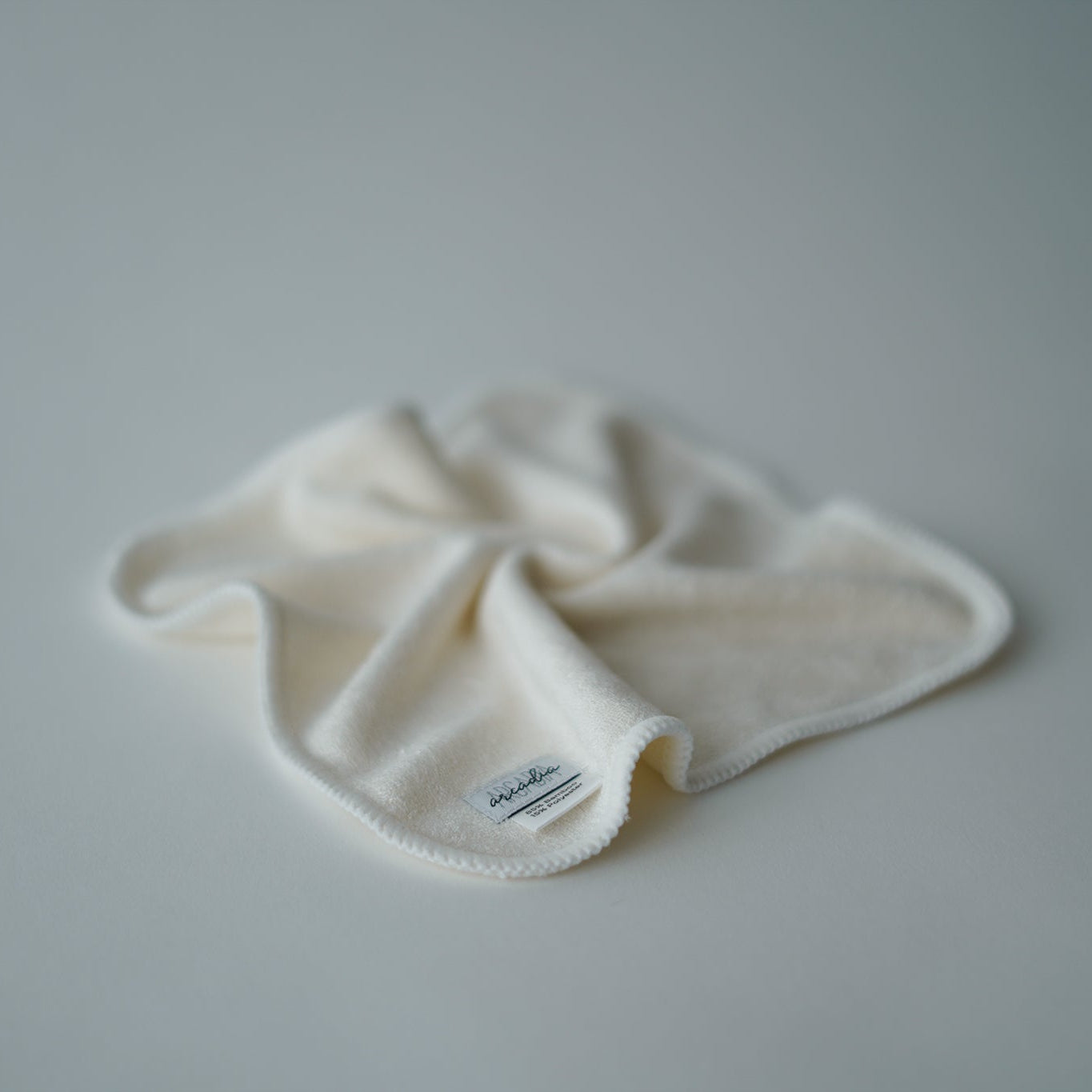 White reusable cloth wipe with an arcadia's Nursery label on a white background