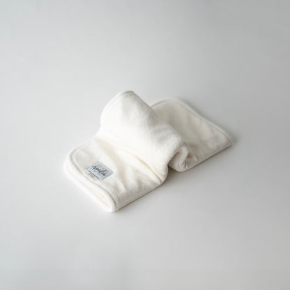 A folded bamboo terry doubler insert for cloth diapers, displayed on a white background, in an inchworm formation.