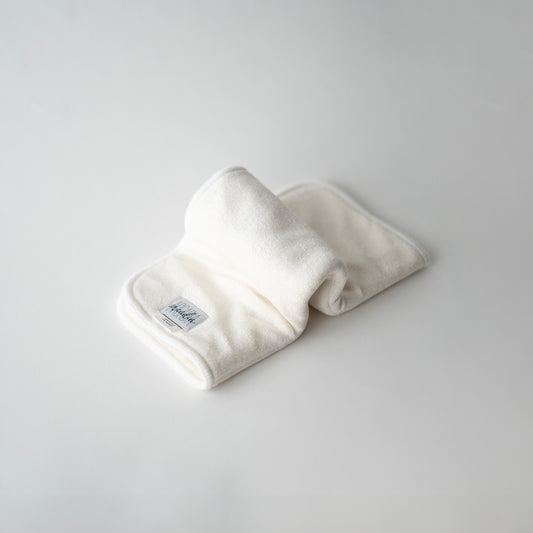A folded bamboo terry doubler insert for cloth diapers, displayed on a white background, in an inchworm formation.