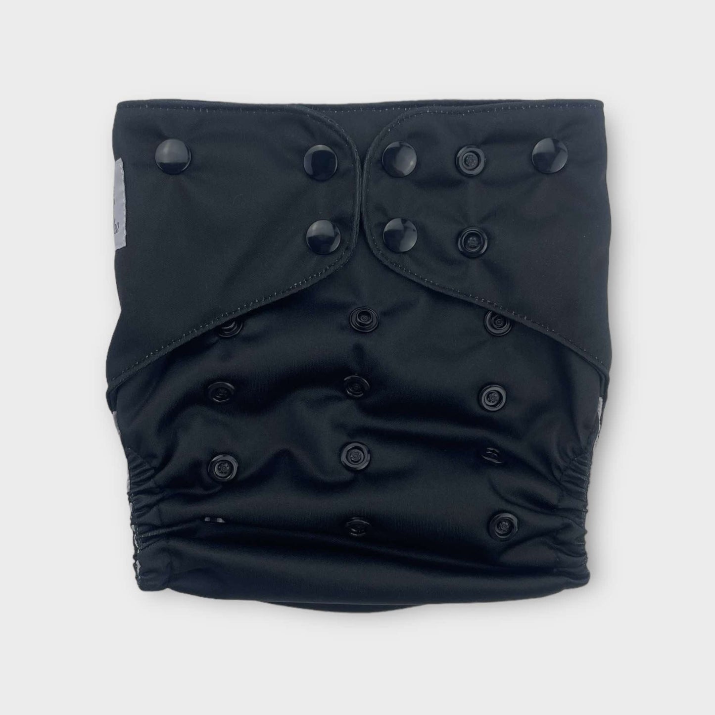 a solid black reusable diaper from wickham wild. the snaps are also black.