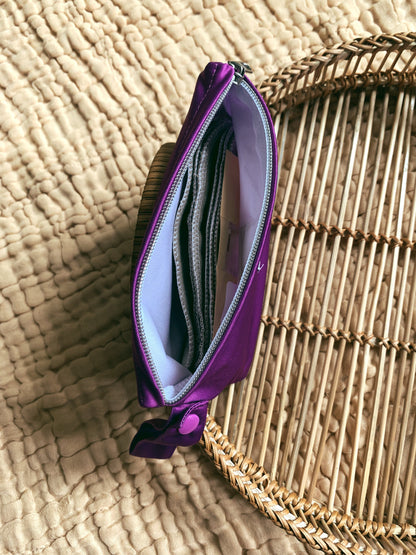 a purple andiamo pouch witht he zipper open from the top showing the size. inside is a wipe bit pouch and cloth wipes.