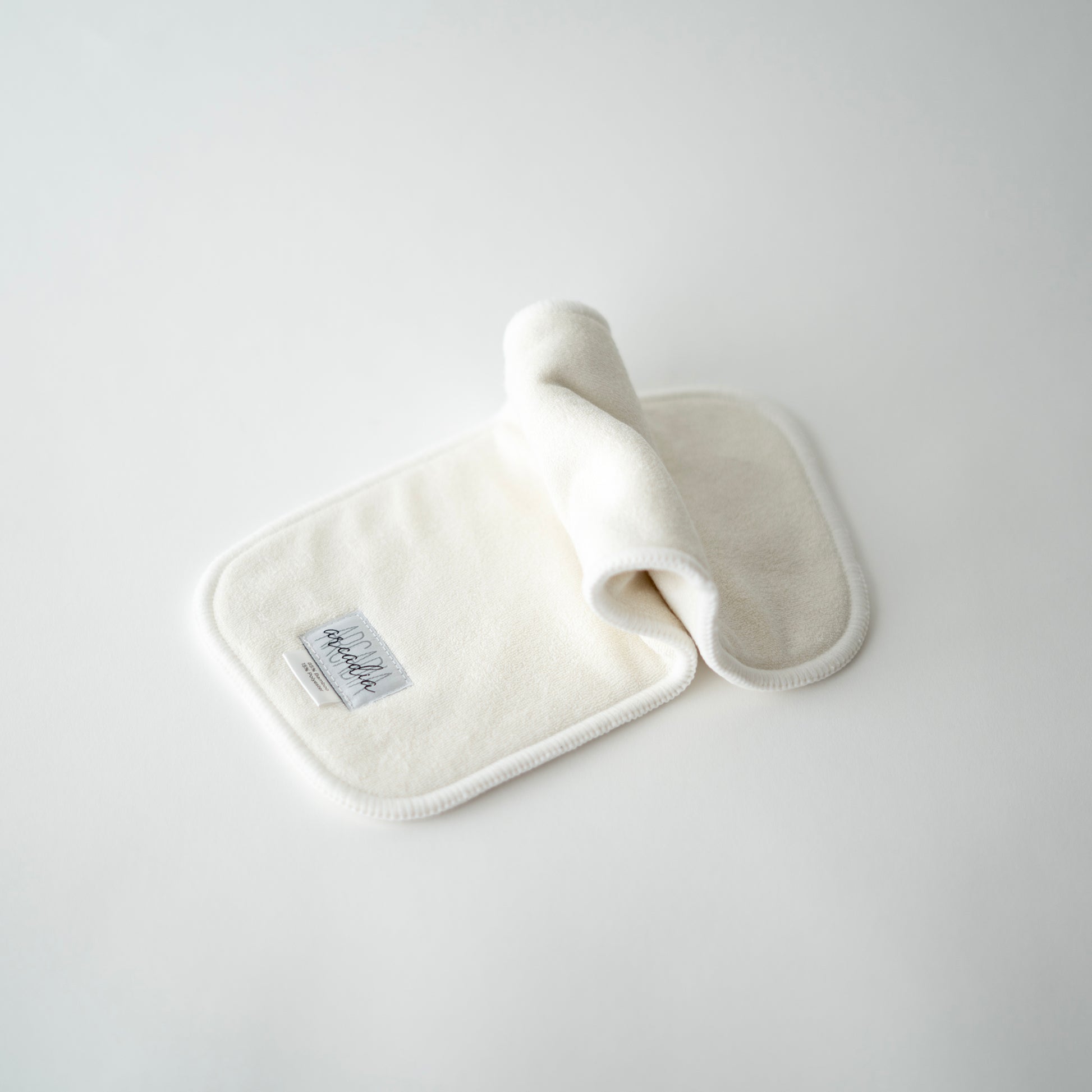 A bamboo terry cloth diaper insert laid out on a white surface, in an inchworm formation.