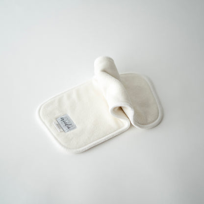 A bamboo terry cloth diaper insert laid out on a white surface, in an inchworm formation.