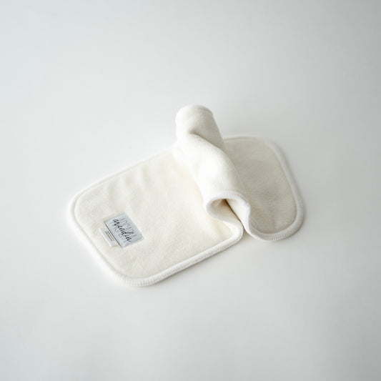 A bamboo terry cloth diaper insert laid out on a white surface, in an inchworm formation.